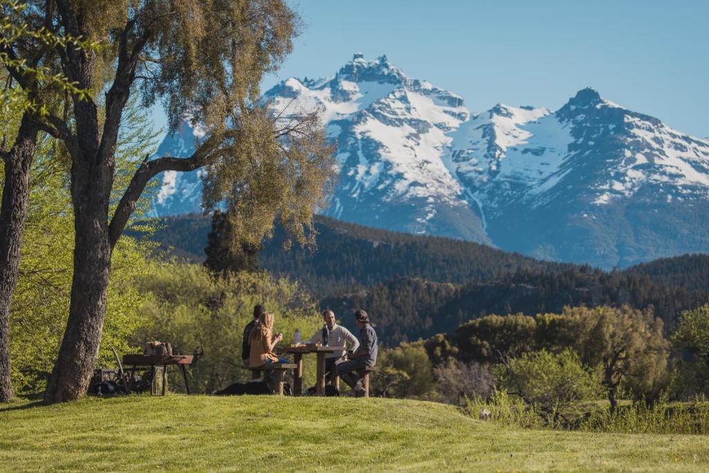 three people sitting at a table with mountains in the background at Los Rebeldes in Baggle