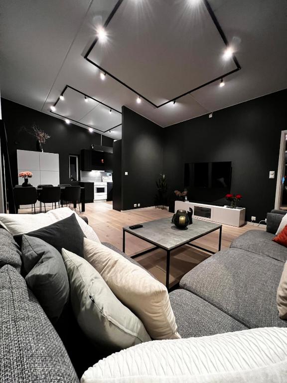 a living room with a couch and a table at Large and airy penthouse, including parking! in Sandnes