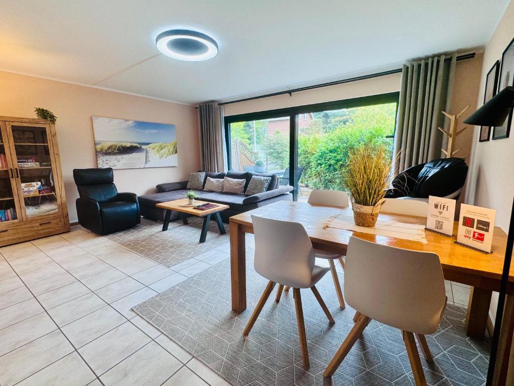 a living room with a table and chairs at Stylisches modernes Apartment, Sauna und Wellness Top Lage in Lübbecke