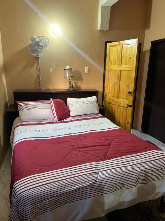 een slaapkamer met een groot bed met rode en witte kussens bij Safety and Serenity in Runaway Bay