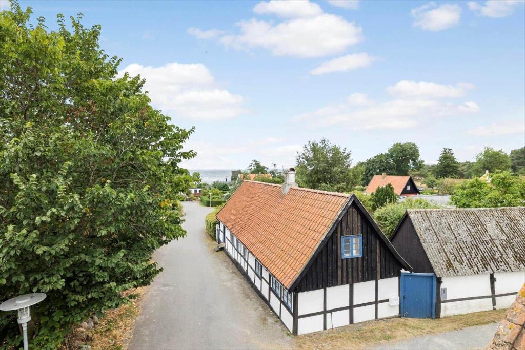 ein altes schwarz-weißes Gebäude und eine Straße in der Unterkunft 5568 Gudhjem - Melsted By 19 in Gudhjem