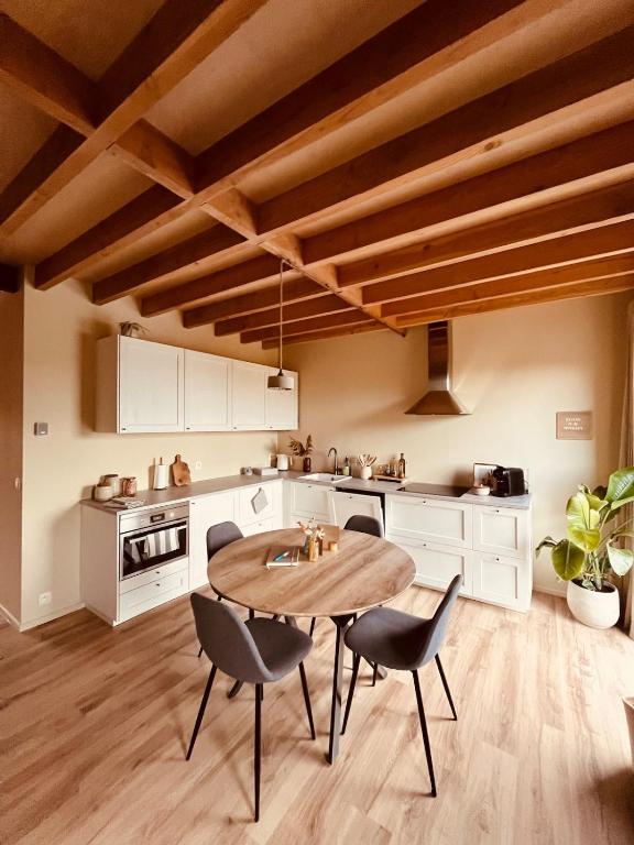 a kitchen with a wooden table and chairs at De Poverleute in Kortrijk