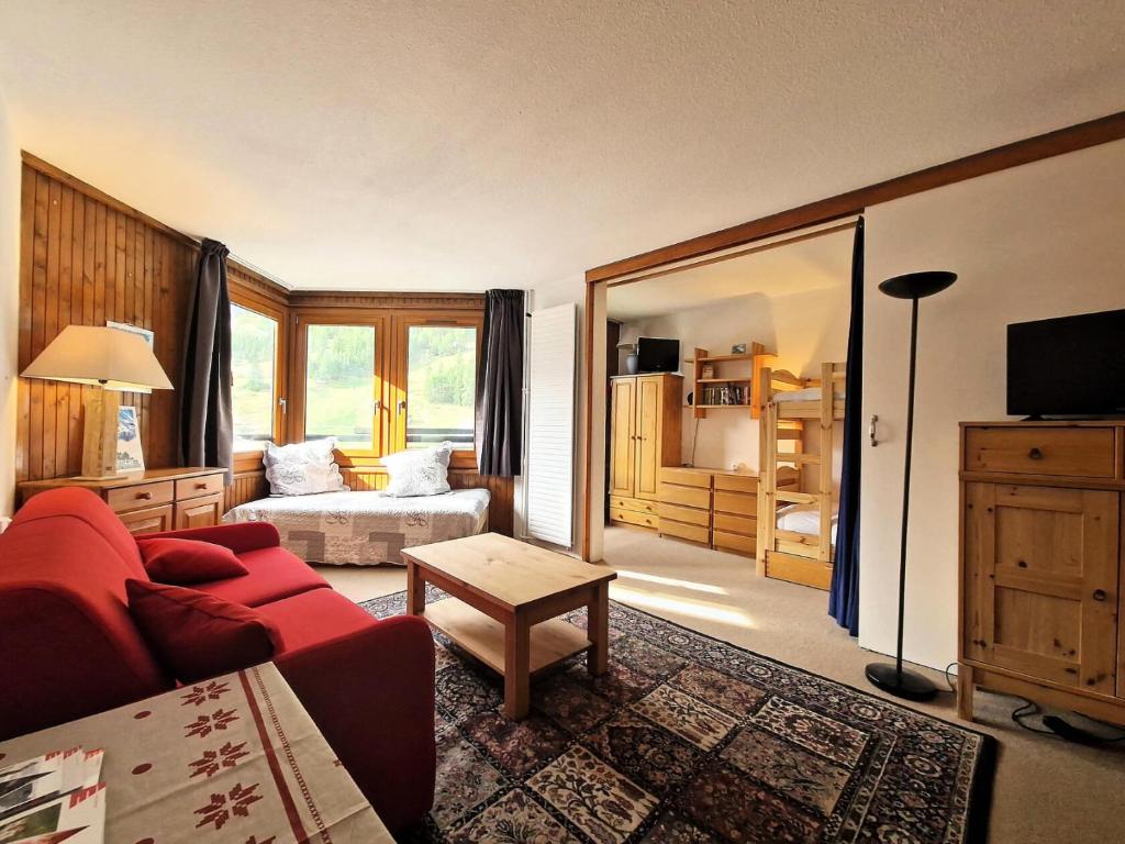 a living room with a red couch and a bed at Résidence Le Vanoise - Studio au pied des pistes et commerces MAE-1533 in Le Crêt