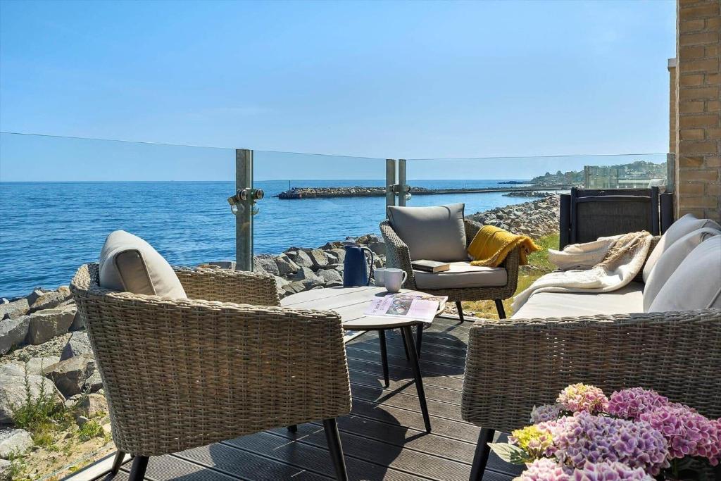a patio with chairs and a table next to the water at 4797-Allinge-Havnevej-14-C-1-th in Allinge