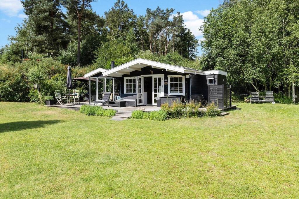 a small cabin in a field with a grass yard at 6832-Hasle-Toftegardsvej-20-C in Hasle