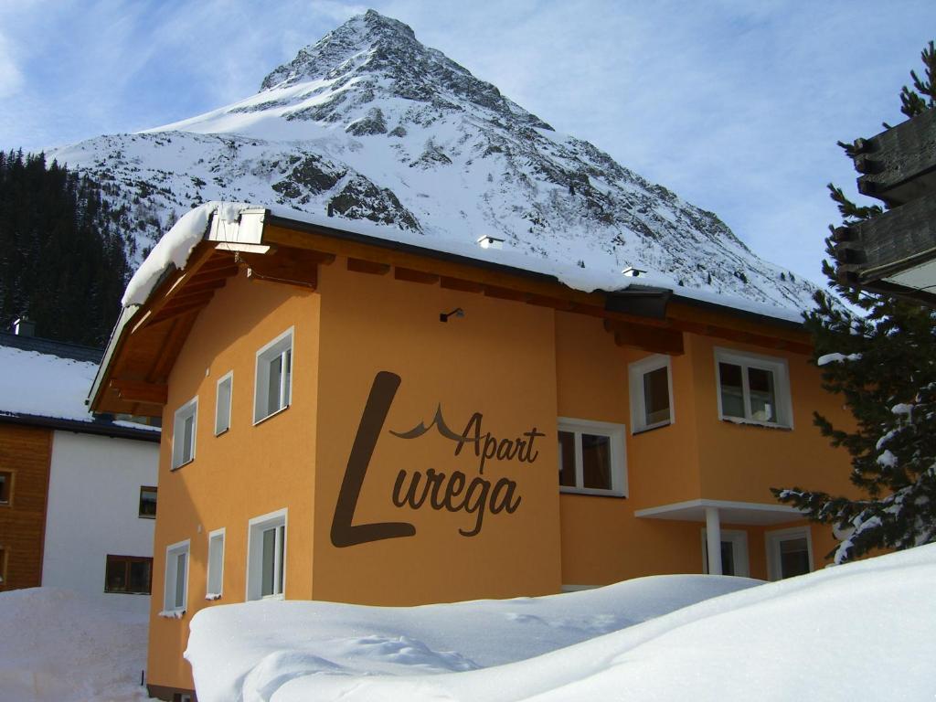 a building with a snow covered mountain in the background at Apart Lurega in Galtür