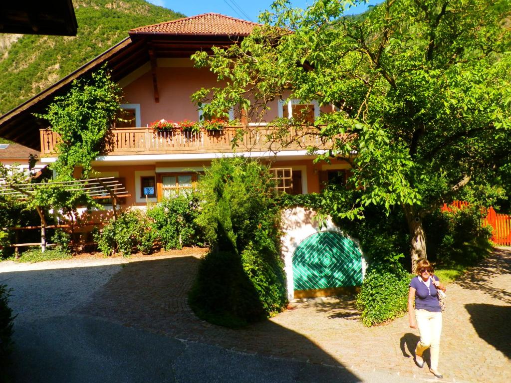 uma mulher em pé em frente a uma casa em Haus Tinkhauser em Vilpiano