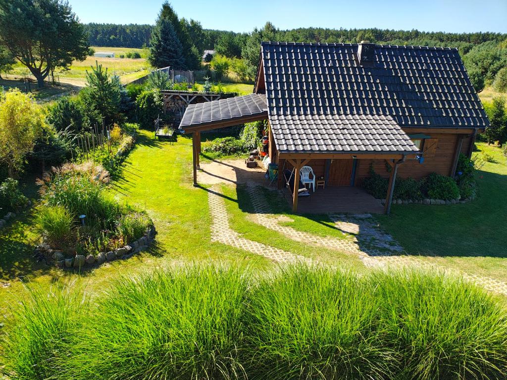eine Luftansicht eines kleinen Hauses mit Garten in der Unterkunft Przystań Natury - Drewniany Dom Wakacyjny in Domysłów