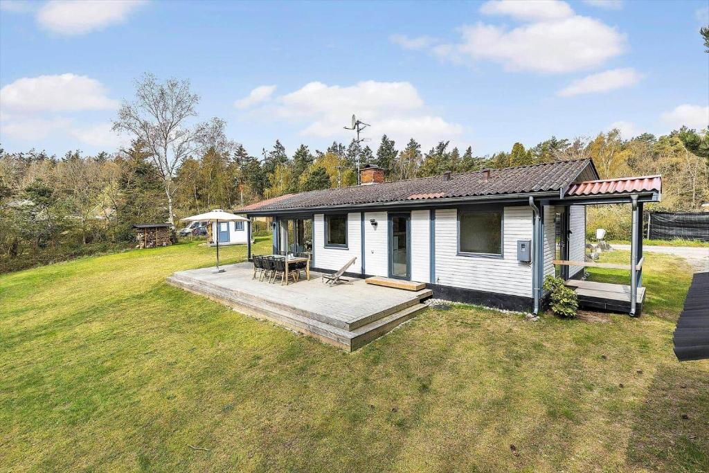 a small white house with a deck in a field at 6718-Hasle-Baga-8 in Hasle