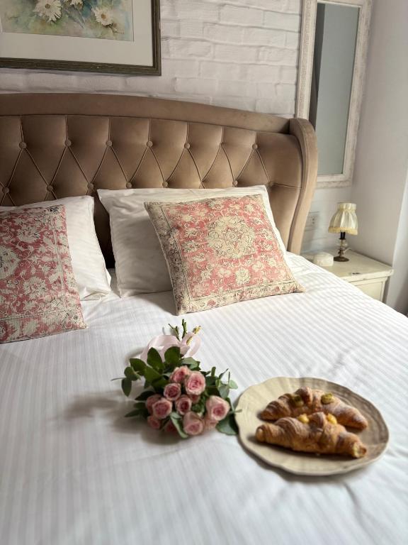 a plate of food and flowers on a bed at Old Town Sibiu Apartment - Historical Center Residence in Sibiu