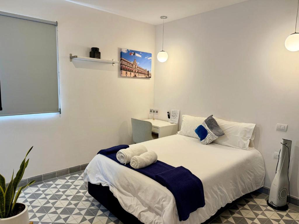 ein Schlafzimmer mit einem Bett und einem Schreibtisch in der Unterkunft Suites Heriberto Frías in Mexiko-Stadt