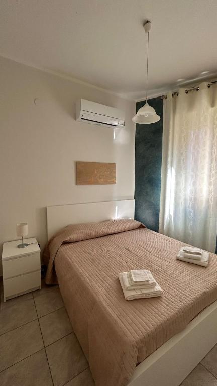 a bedroom with a bed with two towels on it at La Lanterna Apartment in Canicattì