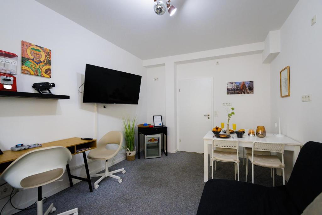 a living room with a desk and a tv on the wall at "Lullus" Apartment im Zentrum von Bad Hersfeld mit privatem Parkplatz in Bad Hersfeld