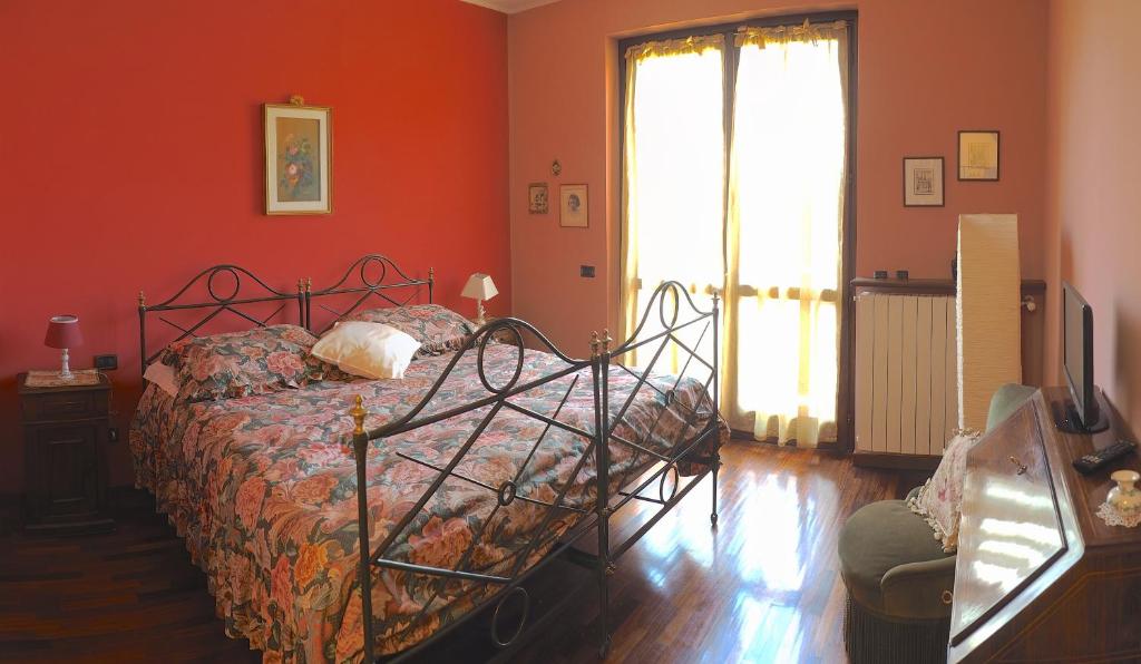 MalnateにあるCa' Rosa Bed & Breakfastのオレンジ色の壁のベッドルーム1室(ベッド1台付)