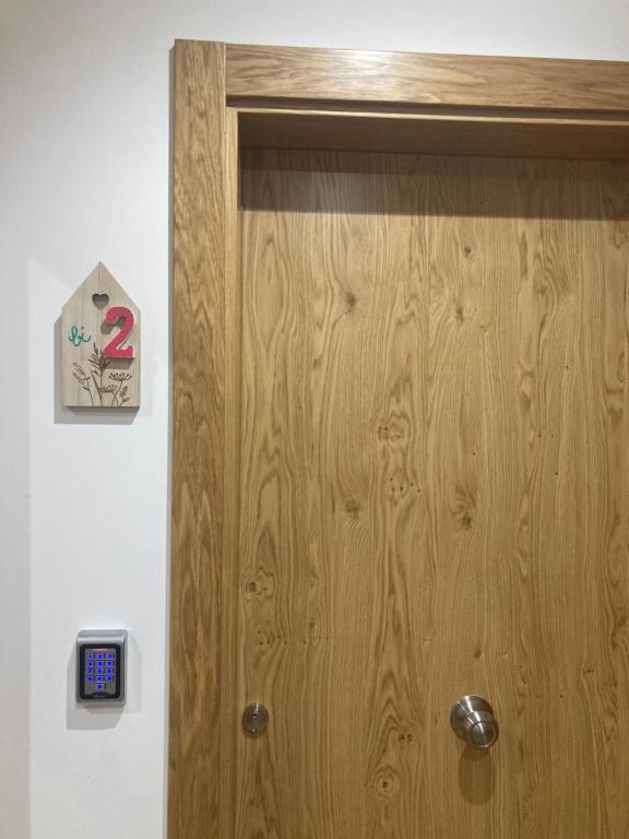 a wooden door with a clock on a wall at Studio&Rooms Ortuzar in Durango