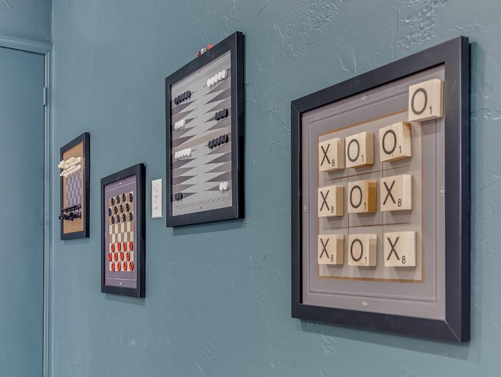 a wall with four framed pictures on a wall at The Big Friendly - A family retreat, heated pool, hot tub, game room minutes away from DT OKC in Oklahoma City
