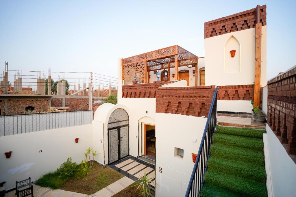 a view of a house with a yard at The Village House with Private Garden - Four Bedroom Nubian Home on Luxor West Bank in Luxor