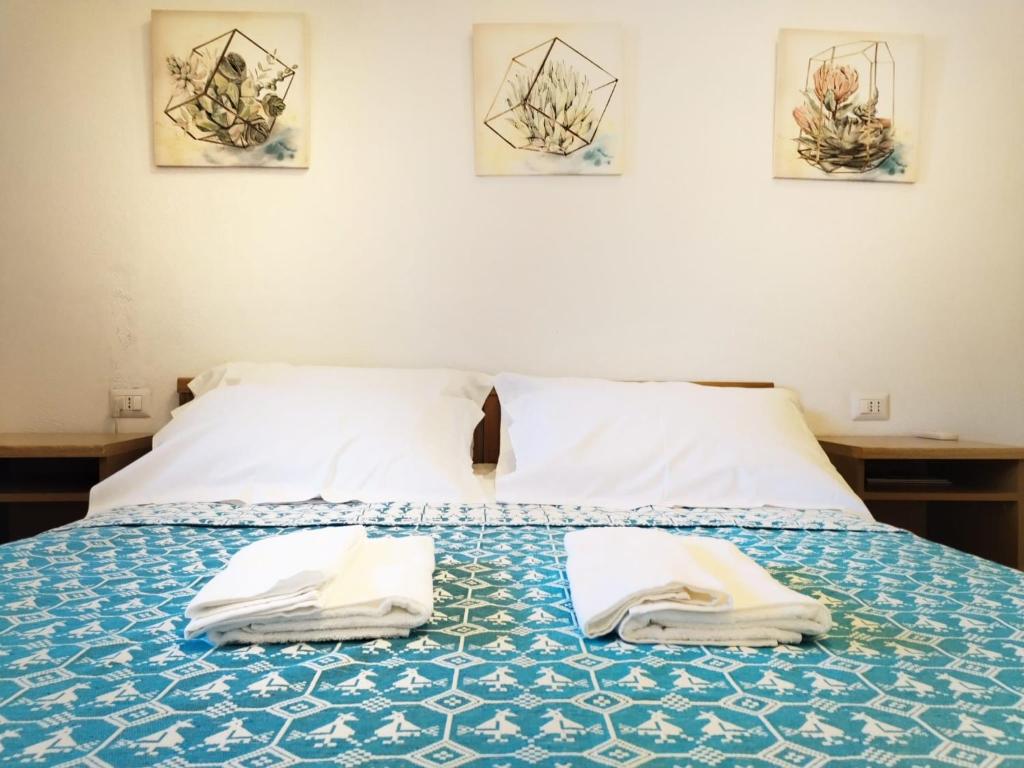 a bed with two towels sitting on top of it at Cactus Apartments - Sea View in Solanas