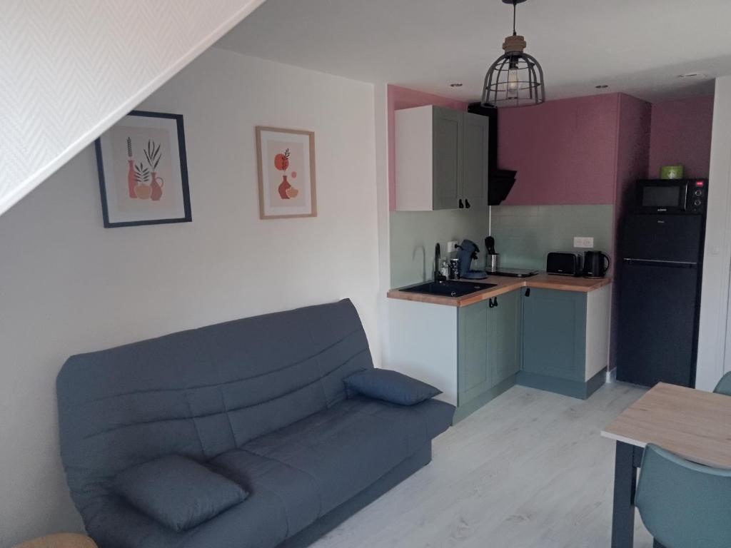 a living room with a couch and a kitchen at Appartement Lilas in Saint-Père