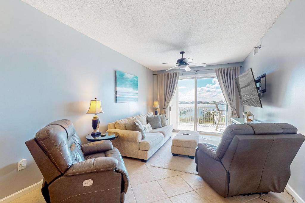 a living room with a couch and chairs and a tv at Harbor Cove #410 in Orange Beach