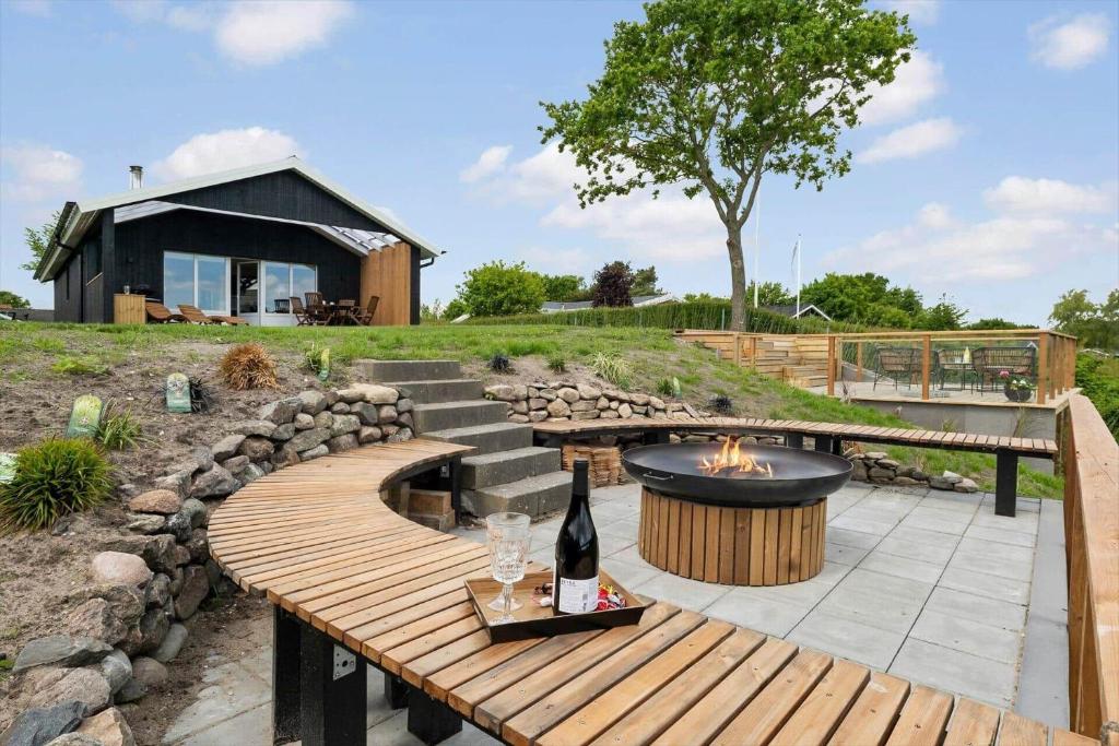 a patio with a fire pit and a table with a bottle of wine at OH291-Hadsund-Mollevaenget-16 in Hadsund