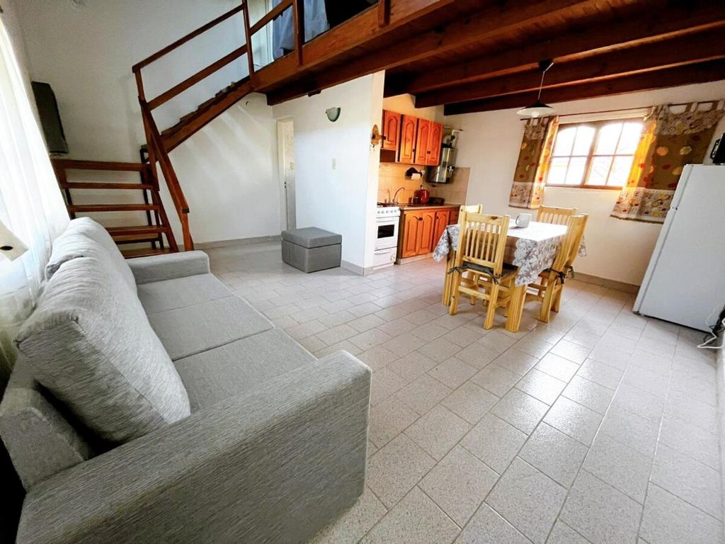 a living room with a couch and a table and a kitchen at Genoveva, descanso y calma in Neuquén
