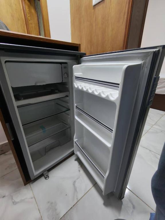 an empty refrigerator with its door open in a kitchen at Del Ceilo Boutique Hotel in Cairo