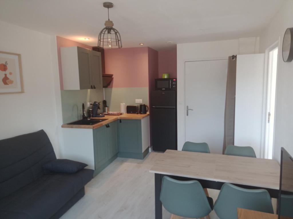 una cucina e un soggiorno con tavolo e sedie di Appartement Lilas a Saint-Père
