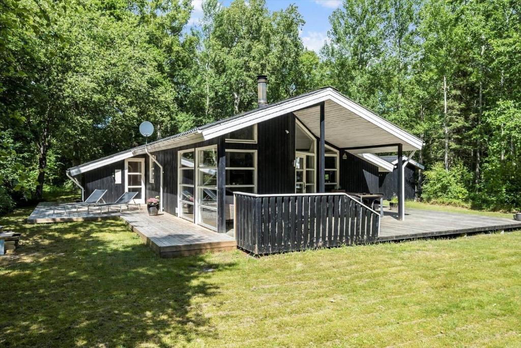 a small house with a large deck in a yard at OH185-Hadsund-Sommerland-39 in Hadsund