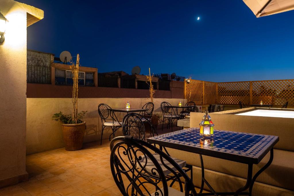 un patio avec tables et chaises sur un toit dans l'établissement Riad Come & Va Medina, à Marrakech