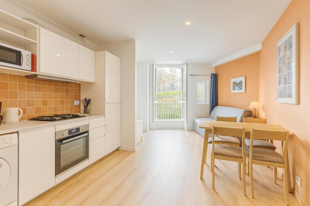 a kitchen with a table and a dining room at Les Appartements Chambon in Sarlat-la-Canéda