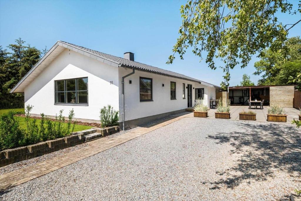 a white house with a gravel driveway at OH465-Hadsund-Havnovej-91 in Hadsund