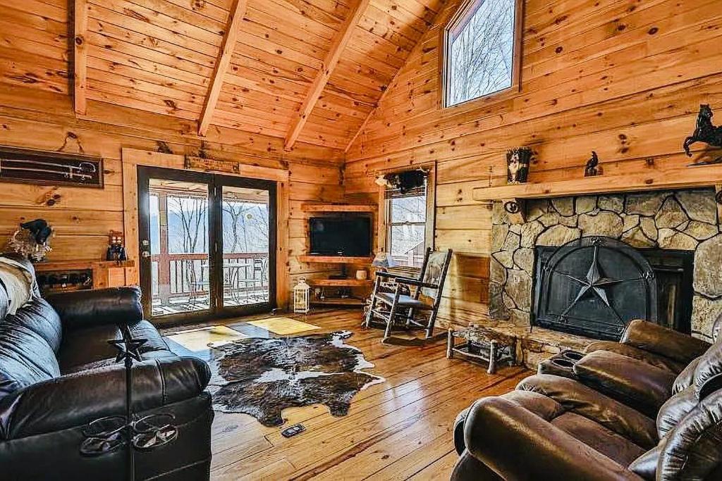 a living room with a couch and a fireplace at Sunset Mountain Cabin in Ellijay