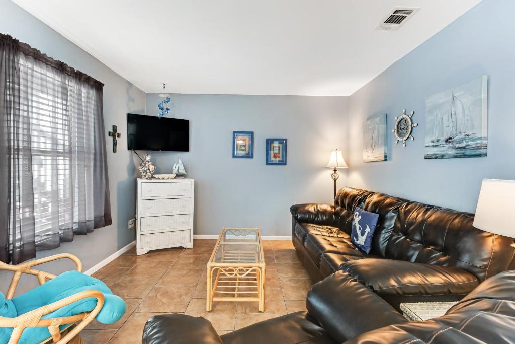 un soggiorno con un divano in pelle e una TV di Ocean Reef 602 a Gulf Shores