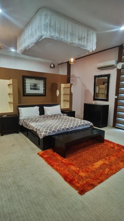 a bedroom with a large bed and a red rug at Waghill Presidential Penthouse in Mwanza