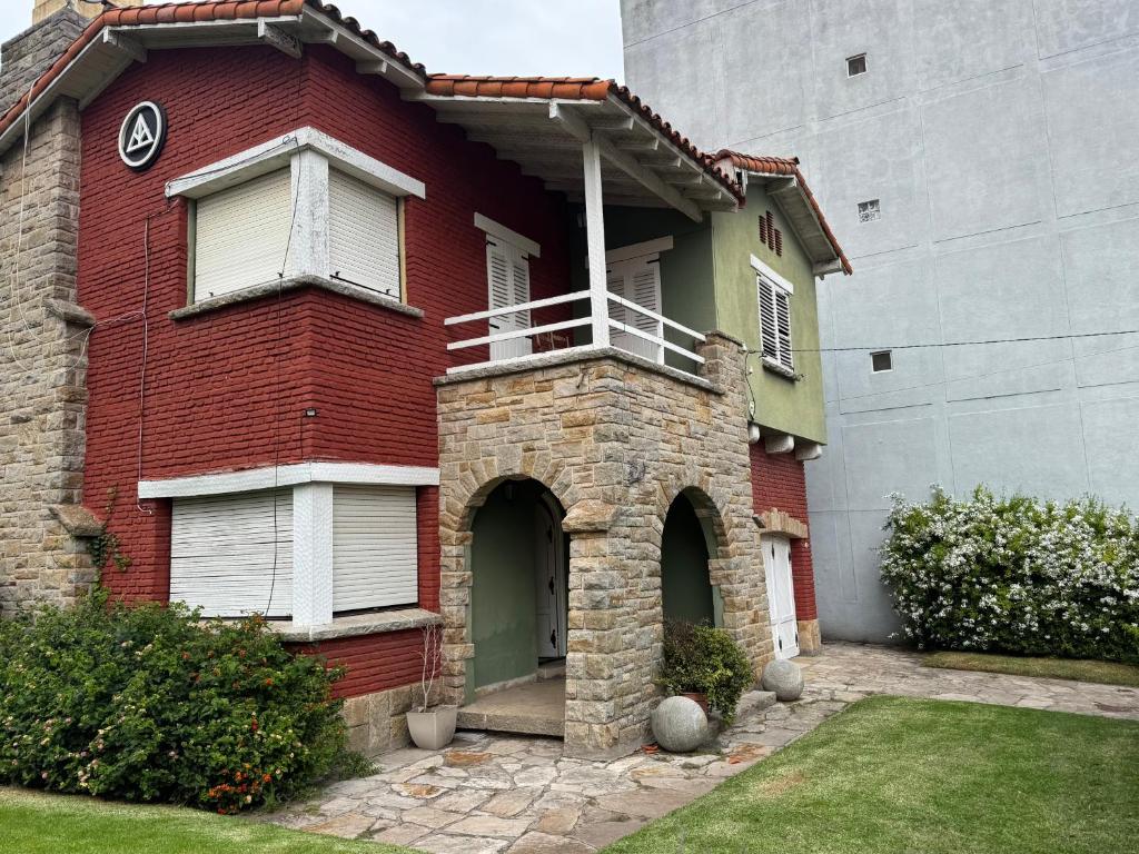 a red brick house with a balcony on it at Casa grande en Miramar con parque, quincho y parrilla in Miramar