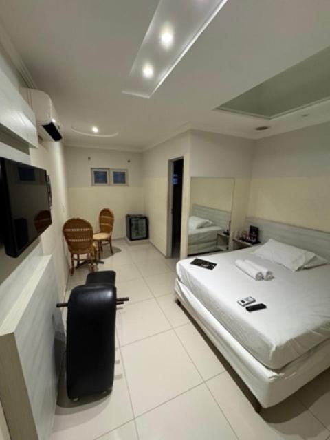 a hotel room with a bed and a table and chairs at D'lazer Motel in Caruaru