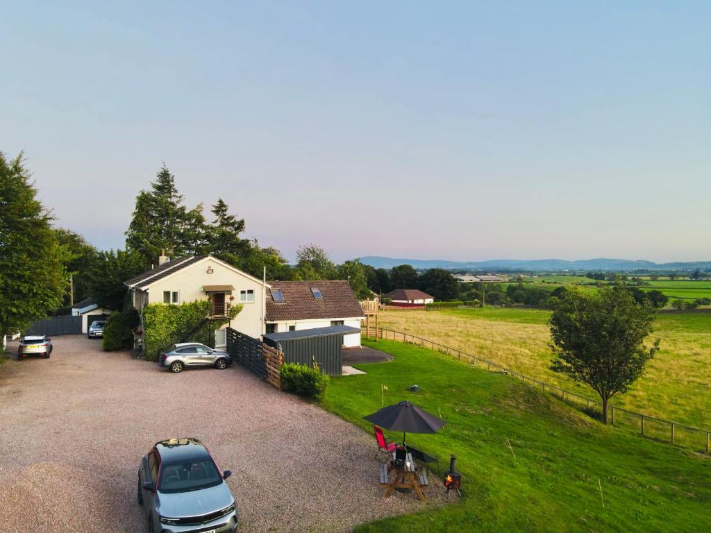 une vue aérienne sur une maison avec une voiture garée dans une allée dans l'établissement Southpark House, à Dumfries