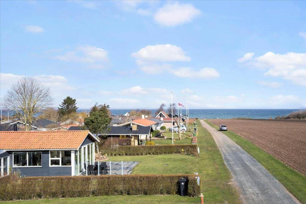una fattoria con una casa, un campo e l'oceano di FY112-Bogense-Laerkevej-4 a Bogense