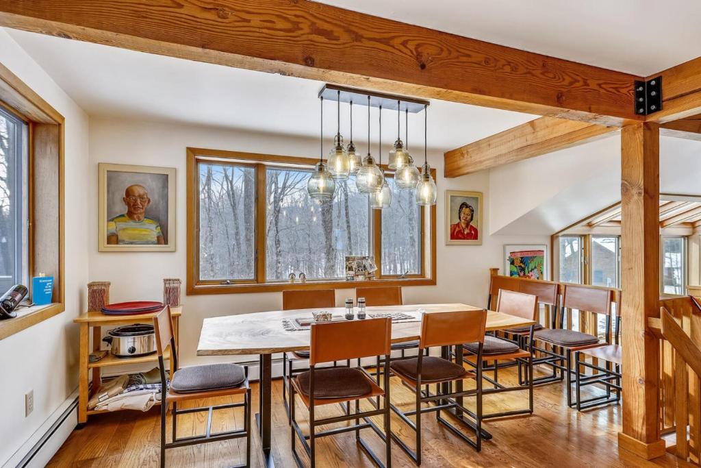 a dining room with a table and chairs at Lakewood Lodge - 4BR, 2BA Ski Home - Private Hot Tub, Wood Fire, Kent Pond & EV Charger in Killington