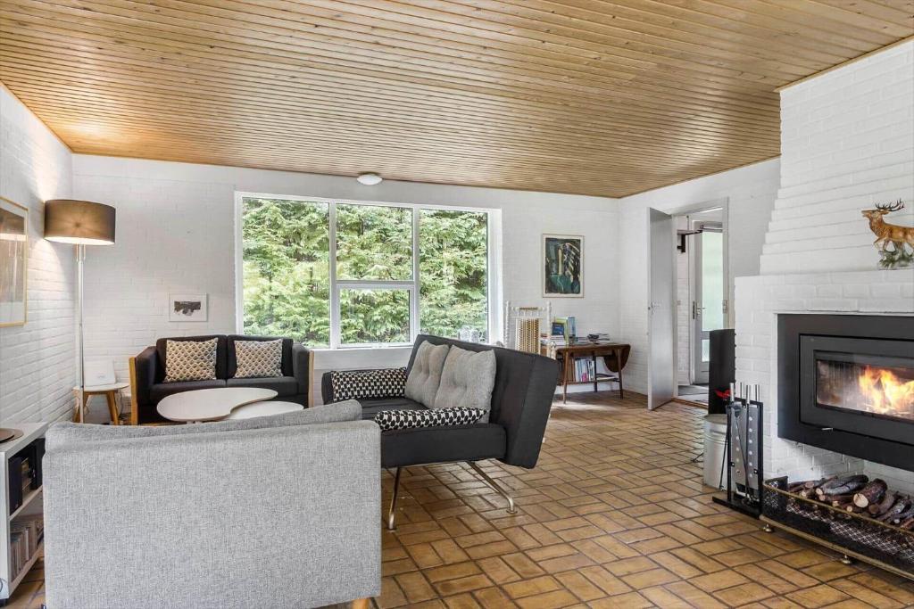 een woonkamer met een bank en een open haard bij LF15143-Hojslev-Mosevej-143 in Højslev