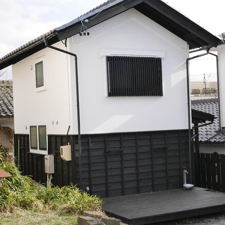 a white and black house with a black fence at Vacation House YORAKURA よら蔵 in Komoro