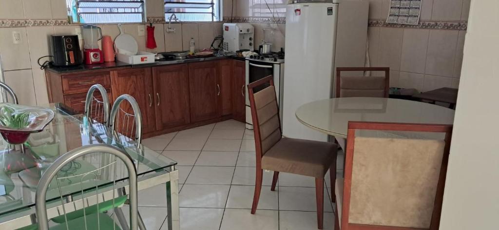 a kitchen with a table and a refrigerator at Casa aconchegante em bairro privilegiado de Belém in Belém