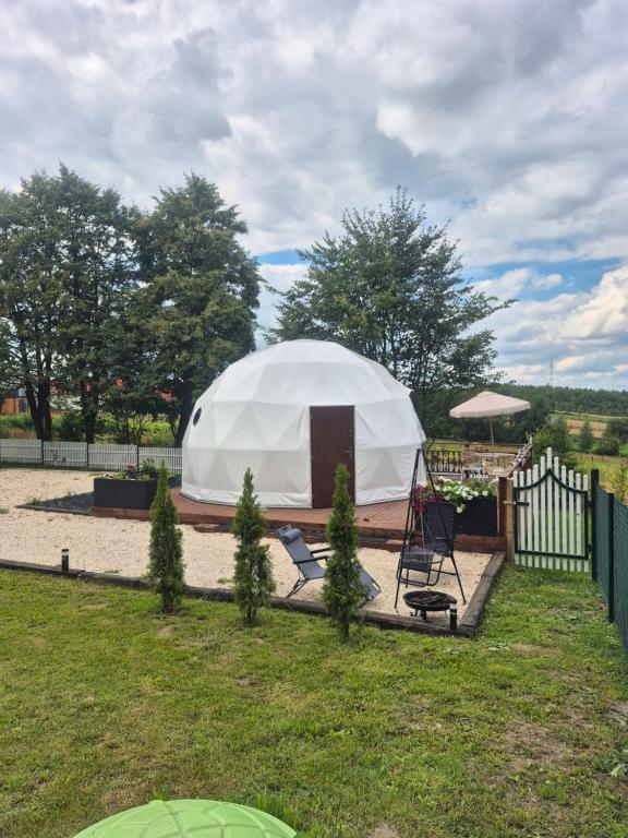 een witte tent in een tuin met een hek bij Glamping Agro Marzenie in Krajno Pierwsze