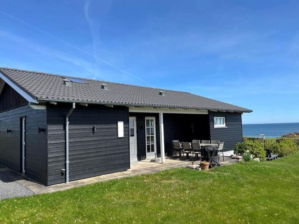 a black shed with a table and chairs in a yard at FY384-Hesselager-Bellisvej-30 in Hesselager