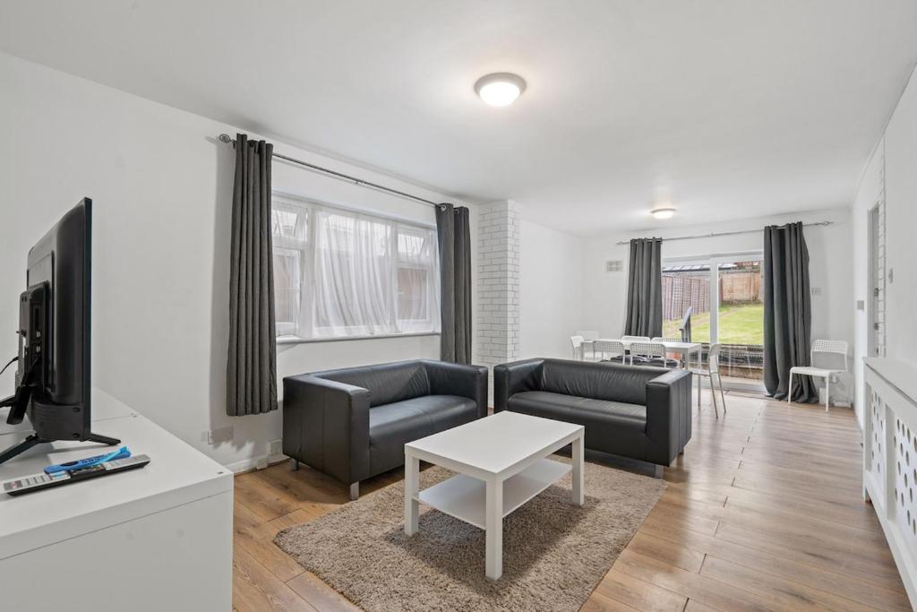 Harrow on the Hillにある6 Beds, 3 Baths, Harrow, Wembley, London 20mins Train to Wembley Stadium, London Maryleboneのソファ、テレビ、テーブルのあるリビングルーム