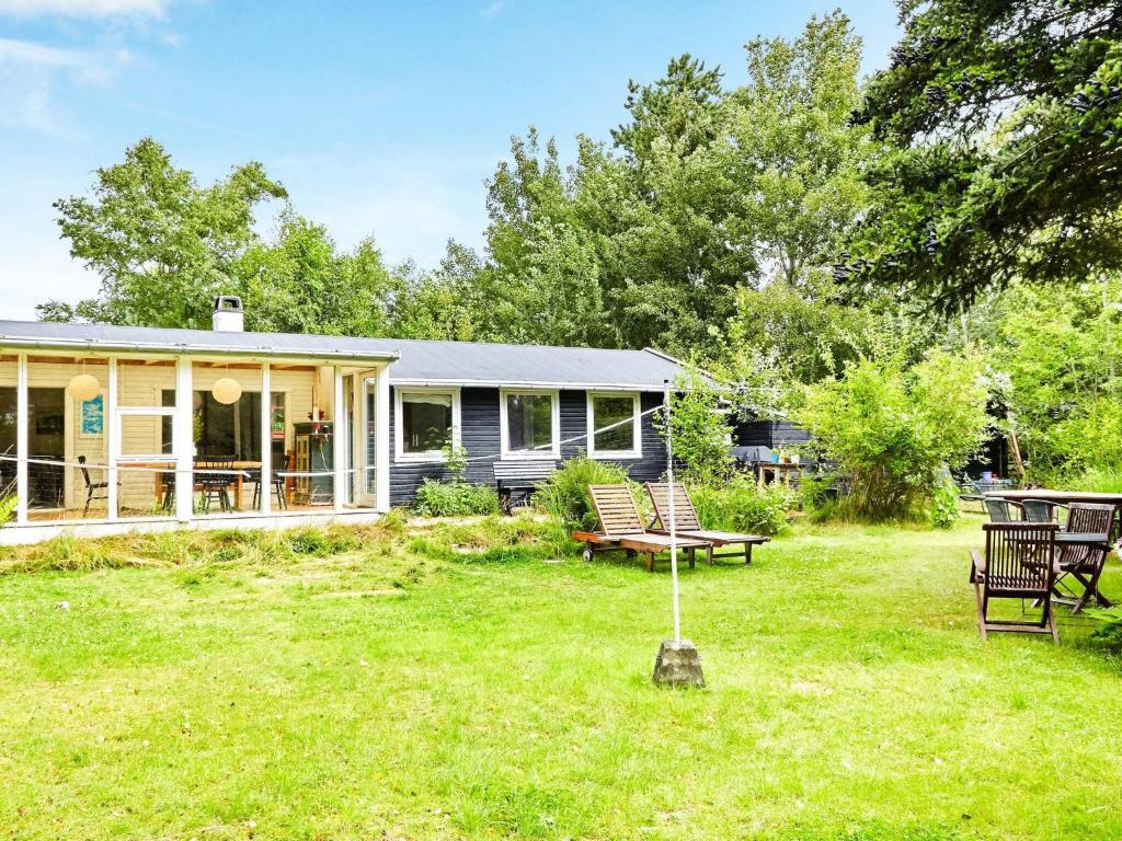 a house with a yard with chairs and a table at 6 person holiday home in Nykøbing Sj-By Traum in Nykøbing Sjælland