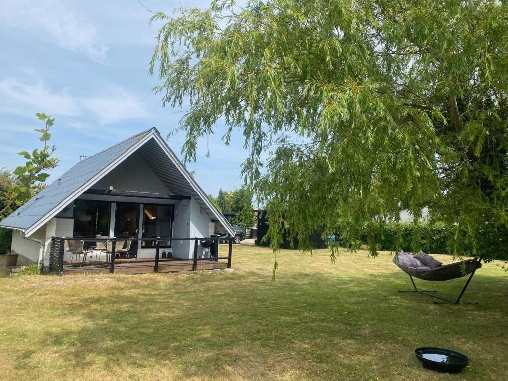 a house with a large yard with a tree at 4 person holiday home in Karrebæksminde-By Traum in Karrebæksminde