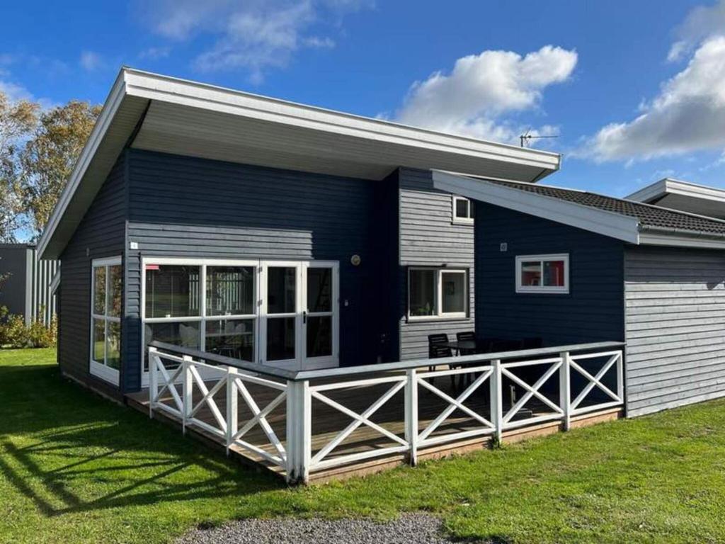 a blue and white house with a porch at 4 person holiday home in Gudhjem in Gudhjem