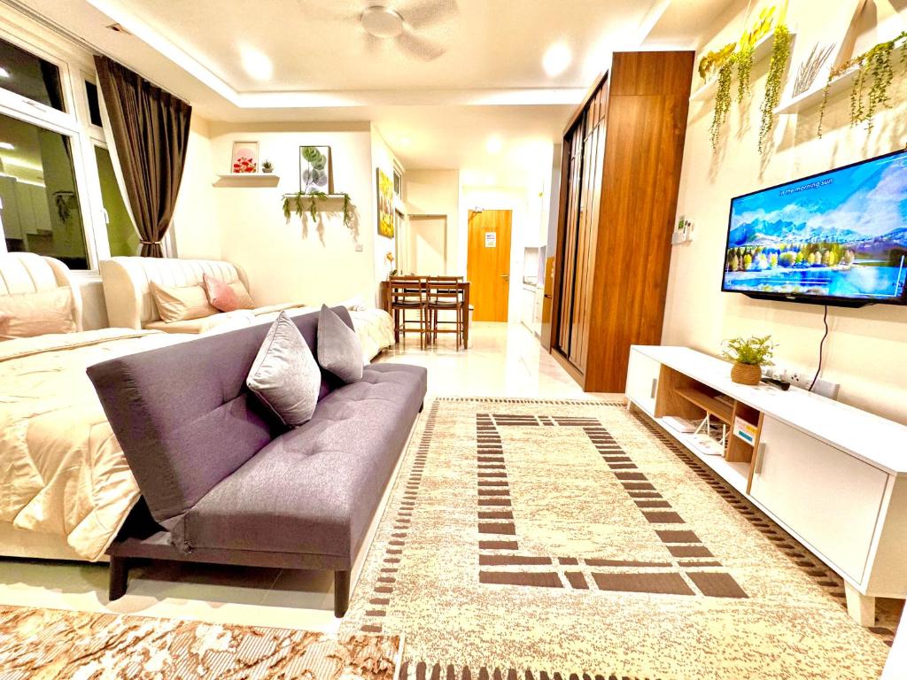 a living room with a couch and a tv at Kuching 4Pax Riverine High Floor Resort Stay Kuching Waterfront View from Balcony in Kuching